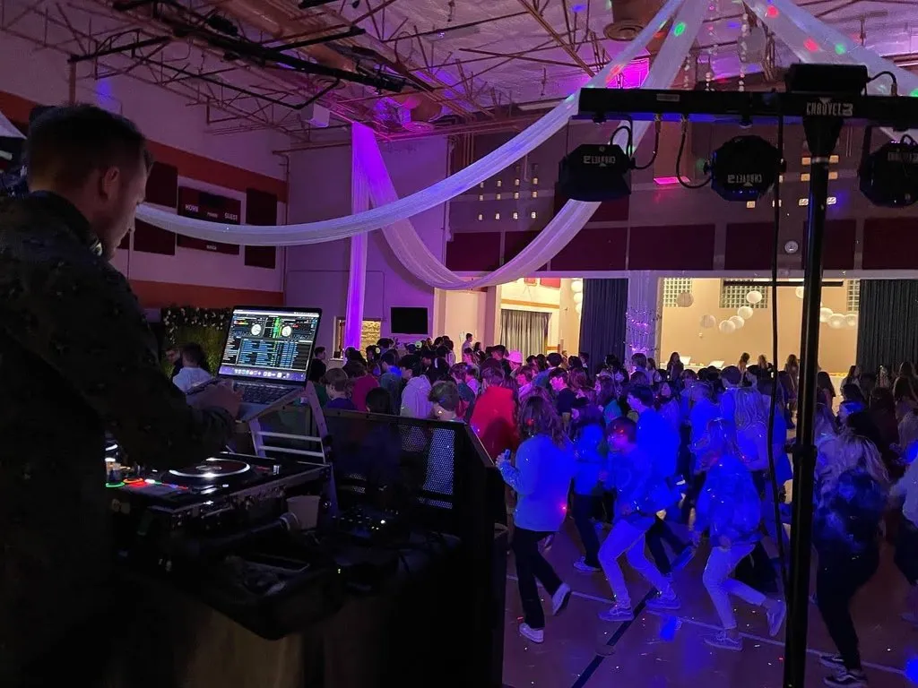 DJ MDDLCHLD performing at a large venue with hundreds of guests dancing